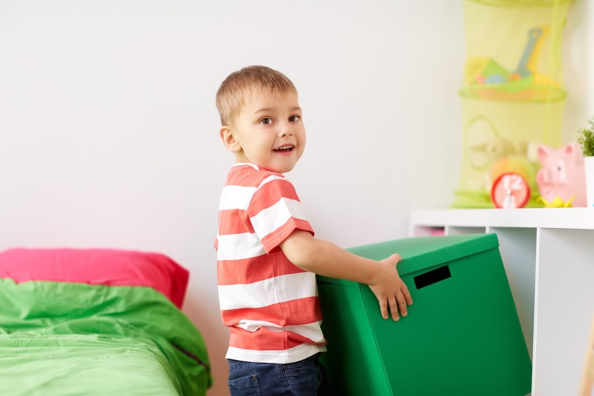 Playroom storage: boy carrying a green box